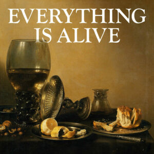 A still life showing a goblet of wine, a peeled clementine, and a loaf of sliced bread against a sepia backdrop, with the text: Everything is Alive.