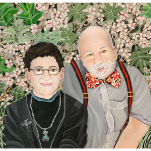 A painting of Jules and Julianne Hirsch, by Tobi Zion. Jules and Julianne are seated side by side. Julianne has short dark hair, and is wearing glasses and a black shirt and jacket. Jules is slightly taller, with no hair on the top of his head and a whitish-gray beard. He is wearing a gray button-down shirt with a red bowtie and red suspenders. They are seated in front of pink flowers and green leaves.