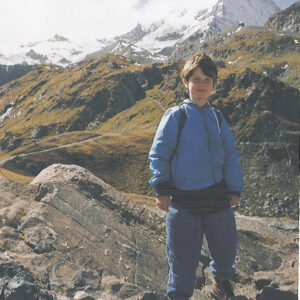 Seven-year-old Nicholas Green, pictured standing on a rock in front of snowy mountains.