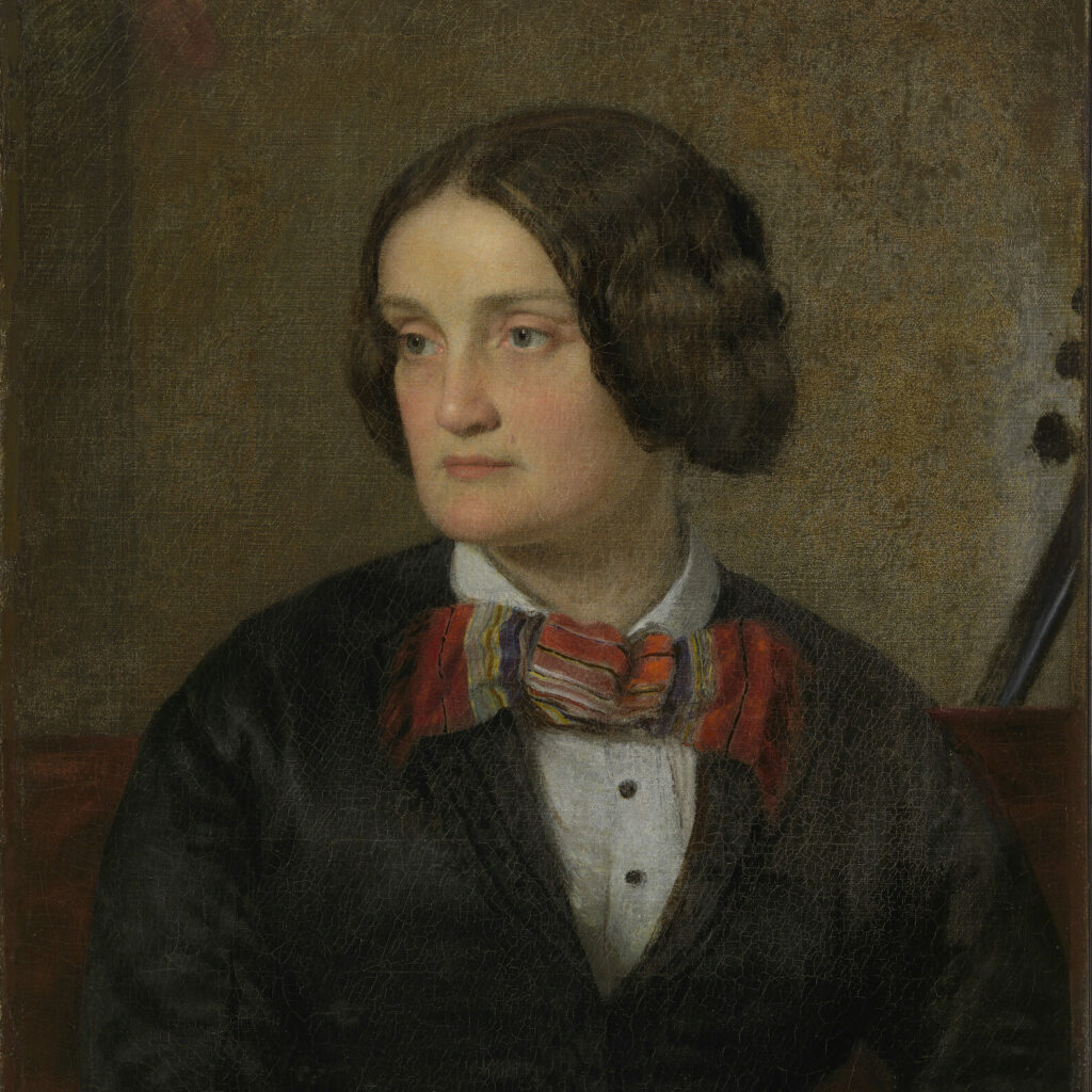 A painting of Charlotte Cushman. She looks away and doesn’t smile. She is wearing a white shirt, dark jacket and a large, floppy bow tie. It is red. Her long, dark hair has been arranged in buns by her ears. The background is painted a warm brown color.