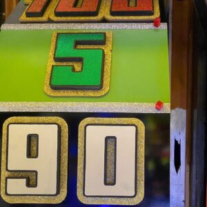 A closeup picture of the big wheel from The Price Is Right. The numbers 90, 5, and 100 are visible and very glittery.